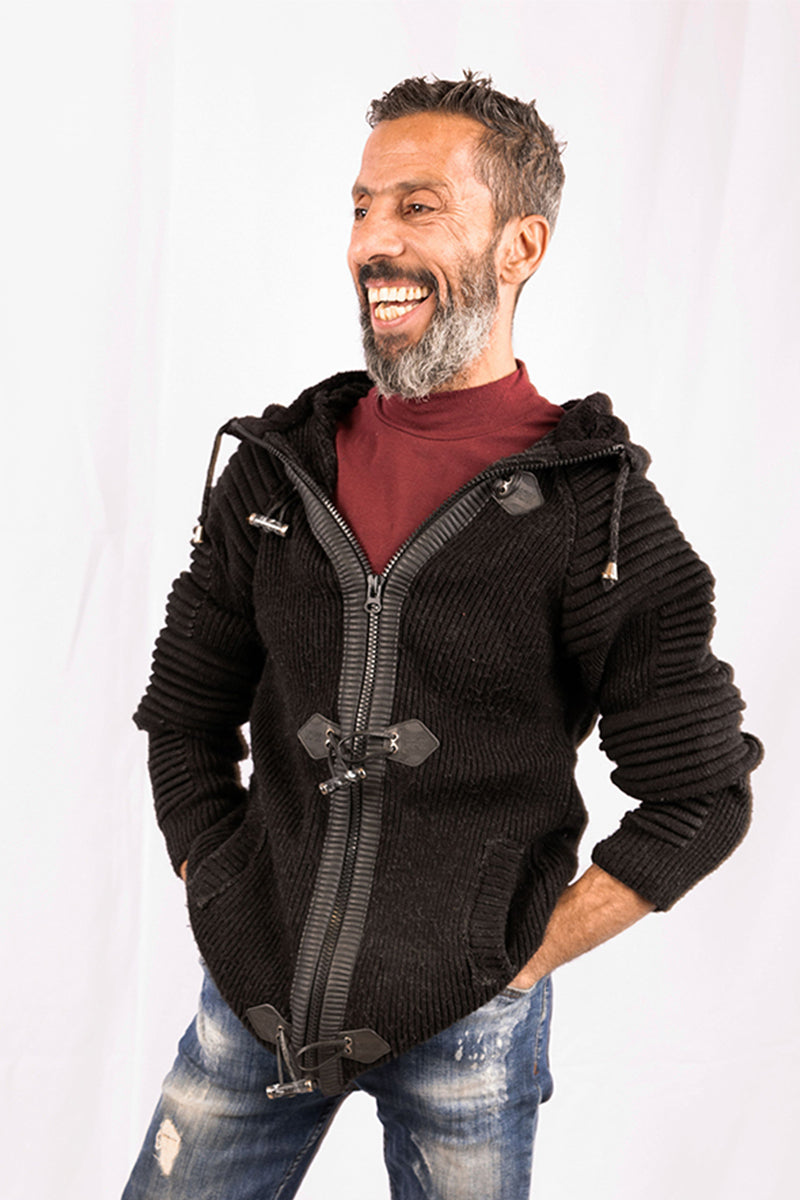 Man wearing a black knitted jacket with a zipper on a white background