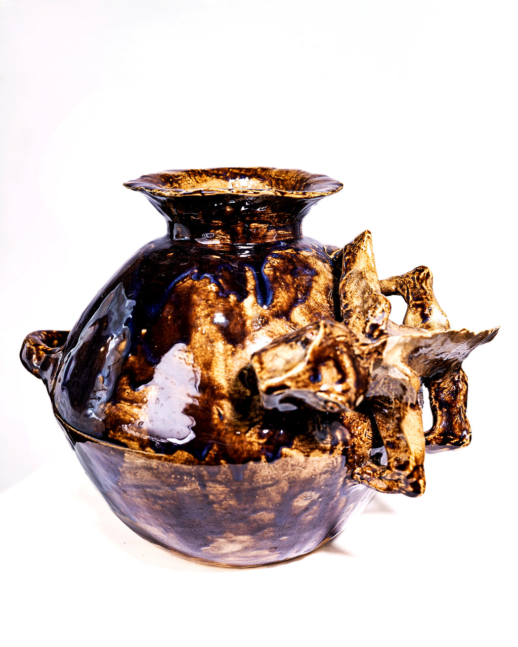 A handmade ceramic vase with a bulbous body, flared rim, side handles, and sculptural organic protrusions on the front and right, finished in a glossy dark brown and black glaze against a white background.